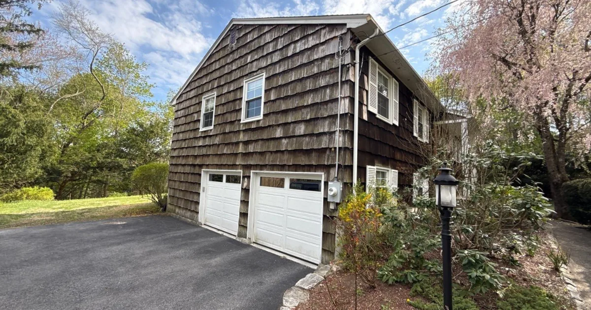 Cedar-shingle colonial with weathered, faded siding before exterior work.