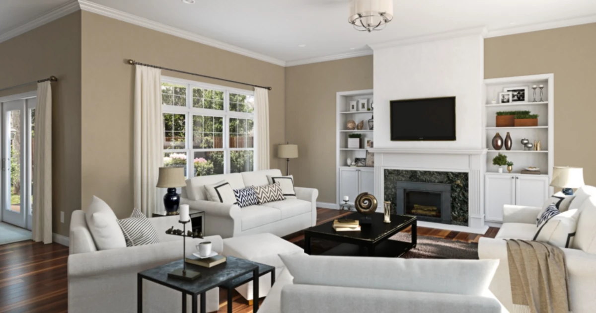 A living room with warm khaki-taupe walls, white sectional sofas, and a fireplace flanked by white built-in shelving.