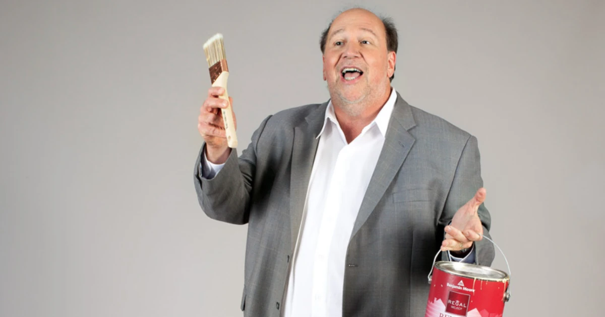 George P. Williams holding a paintbrush and a red paint can.