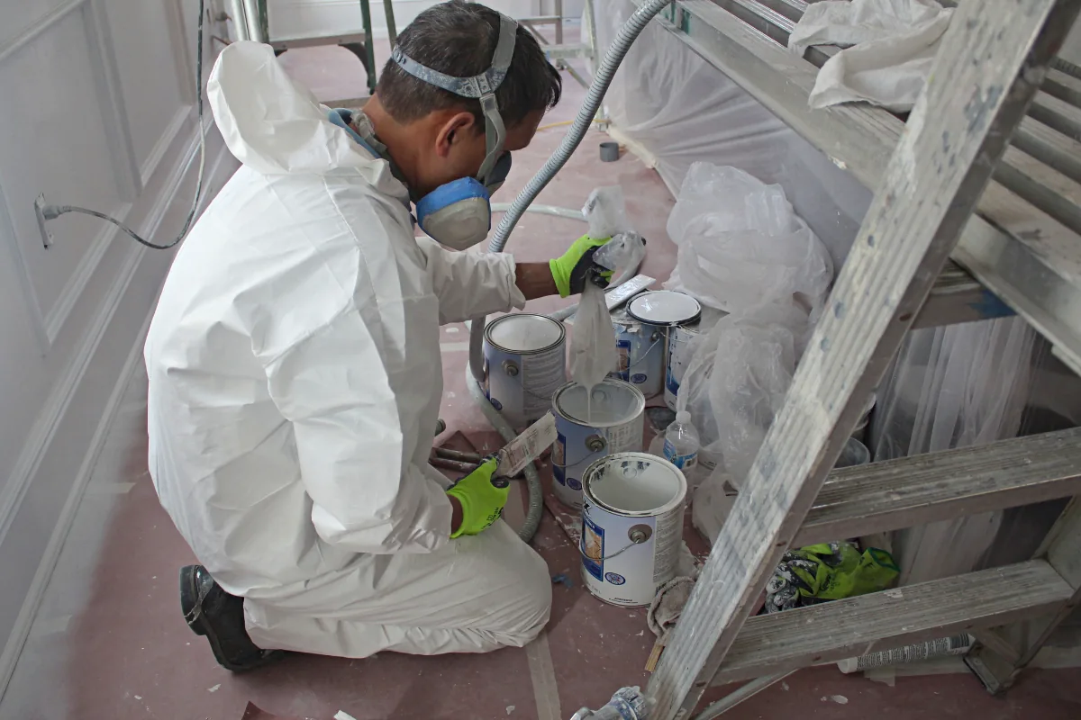An A.G. Williams craftsman preparing bonding primer for kitchen cabinets.