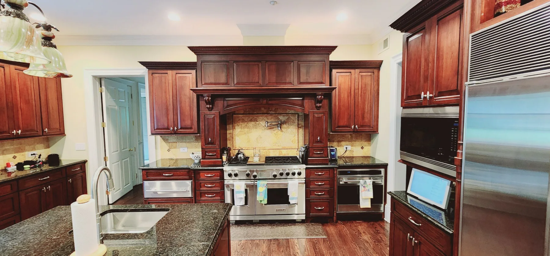 Kitchen with dark wood cabinetry before interior painting.