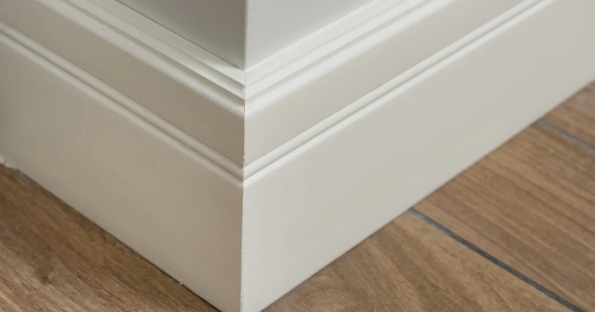 Close view of crisp white baseboard molding at an interior corner.