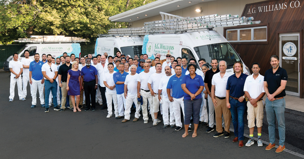 The A.G. Williams team in front of the company office and vans.