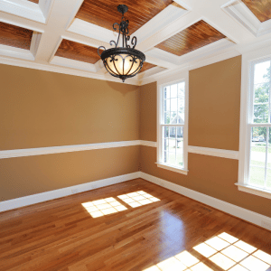 warm tan walls with white chair rail and wooden floors. Ceiling has wood and trim installec