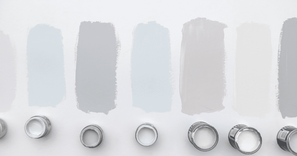 Gray paint swatches and paint cans showing a range of light to medium shades.