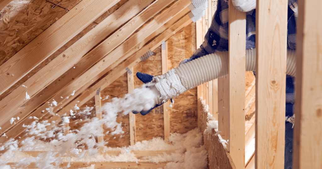 Insulation being installed in an attic for improved home energy efficiency.