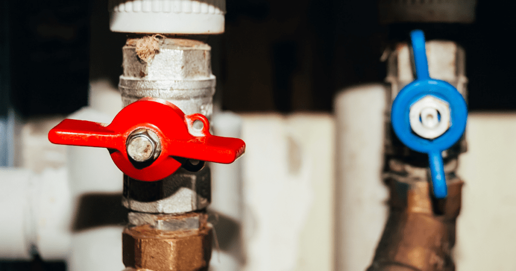 Red and blue water shut-off valves for household plumbing maintenance.