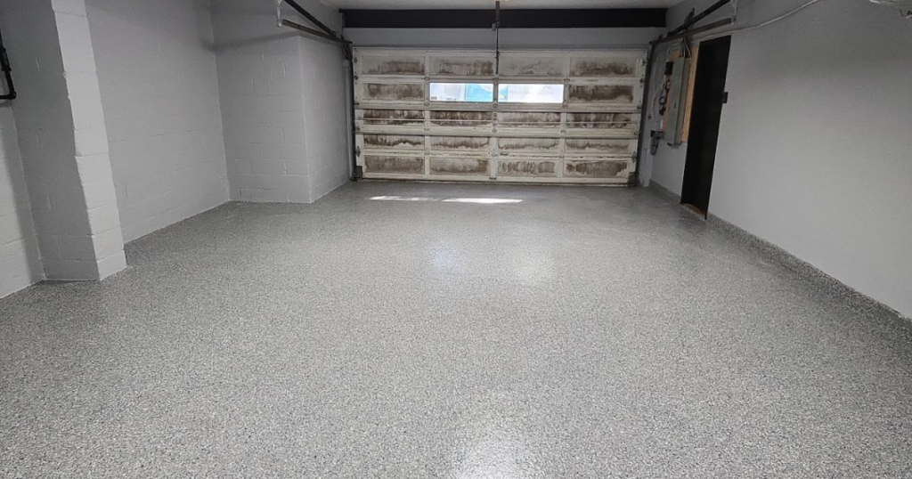 Freshly coated garage floor with a seamless, gray polyurea finish, offering a durable and sleek appearance.