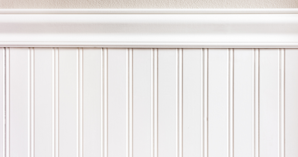 White beadboard paneling with a smooth chair rail, adding a touch of classic charm to a neutral-toned interior.