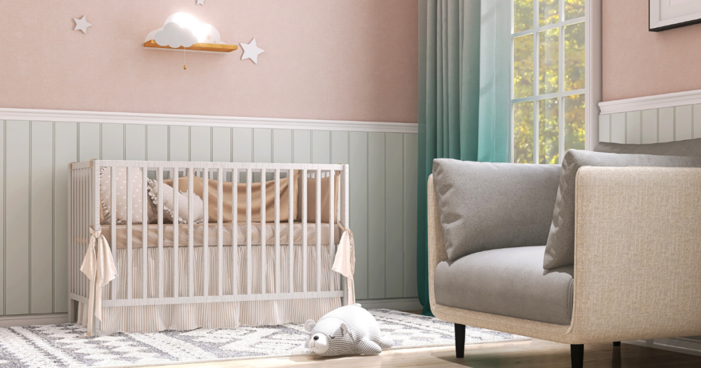 A cozy nursery featuring pastel green wainscoting, a blush pink wall, and a white crib with soft bedding accents.